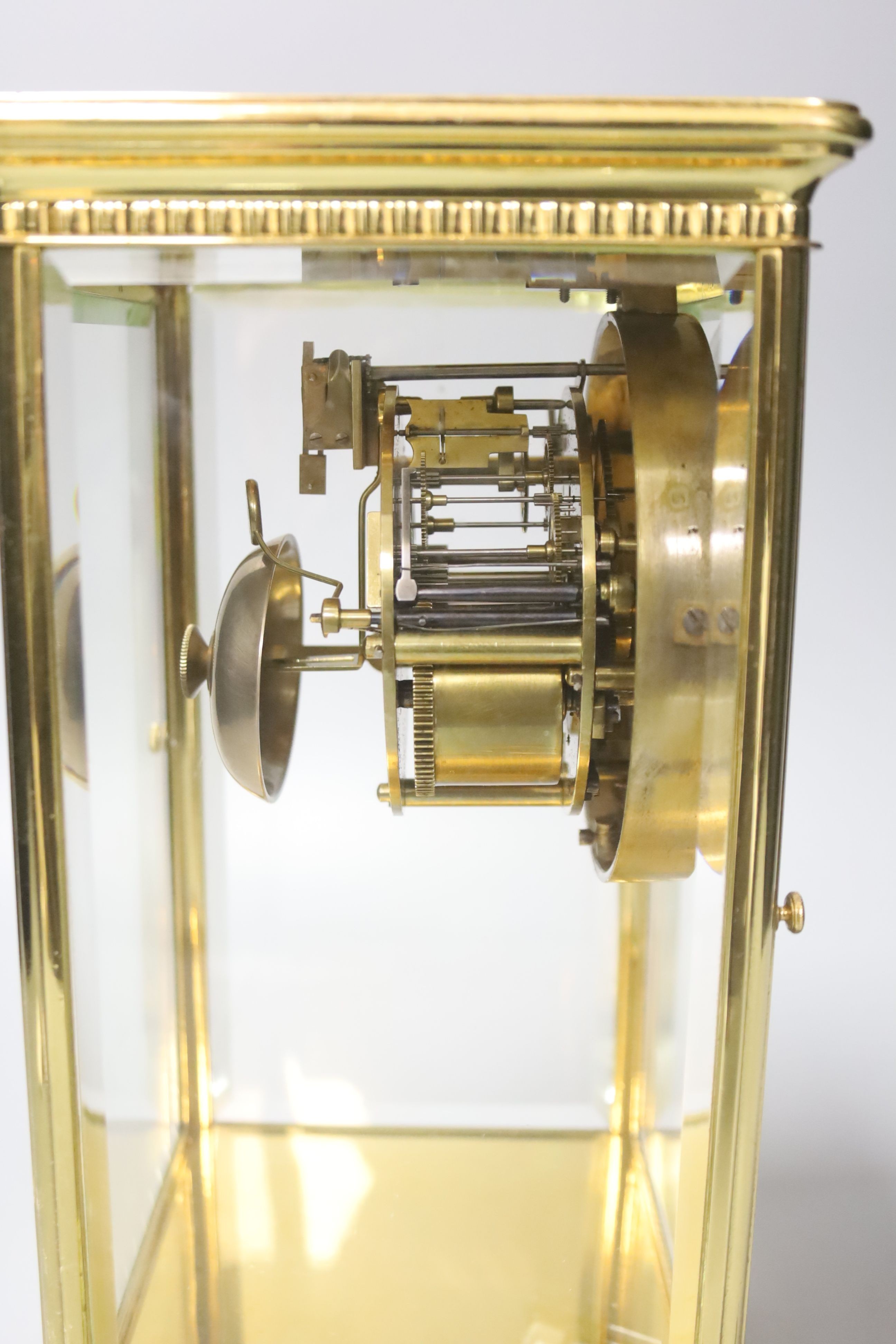 A French brass four glass clock, key and pendulum 27cm